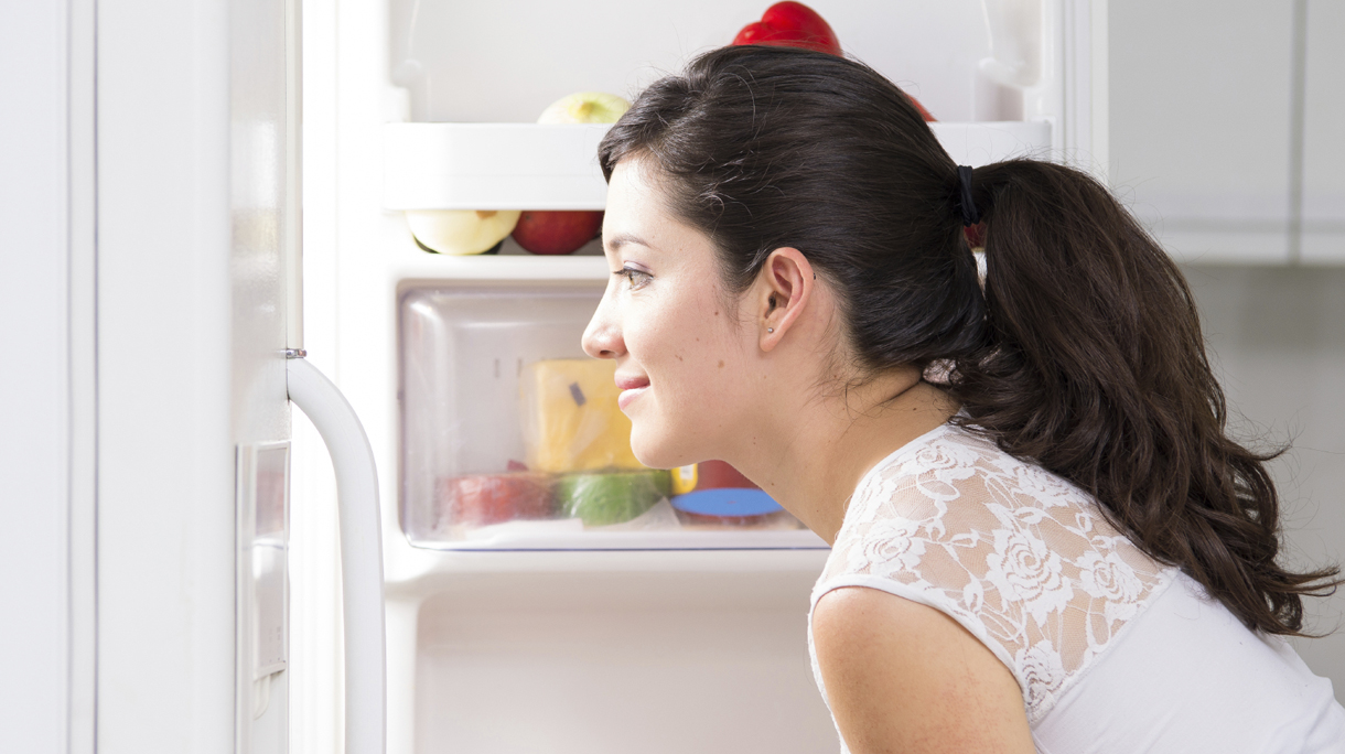young beautiful woman searching for food in the fridge