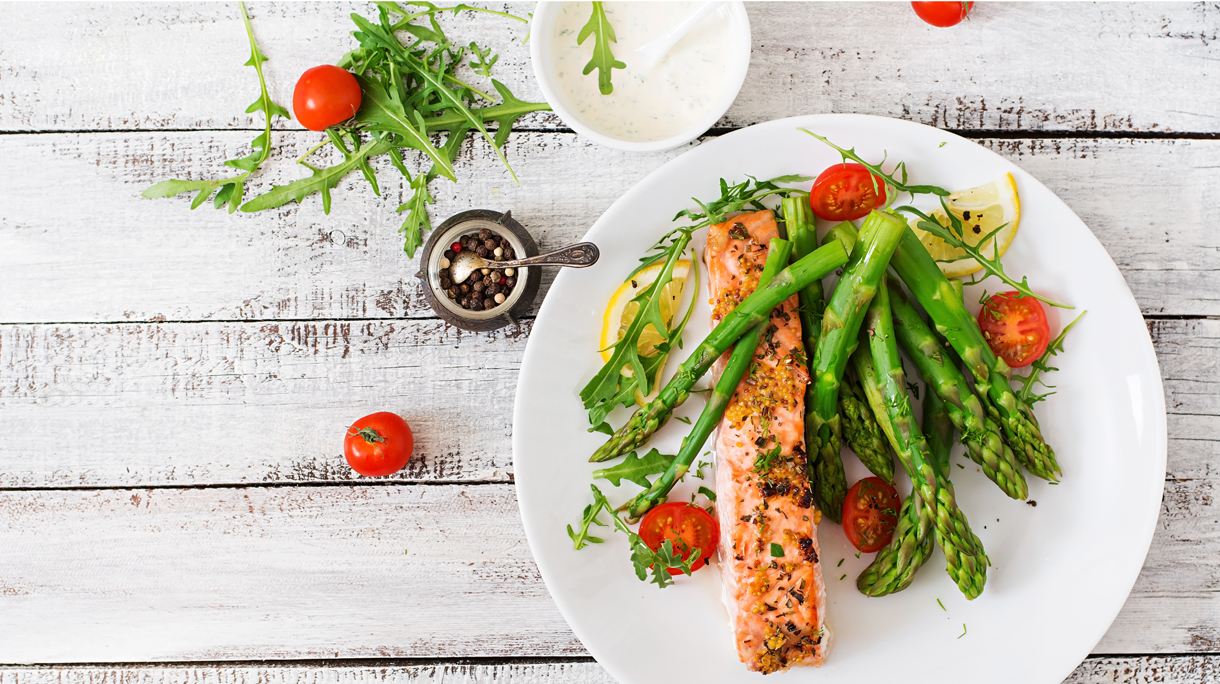 Baked salmon garnished with asparagus and tomatoes with herbs
