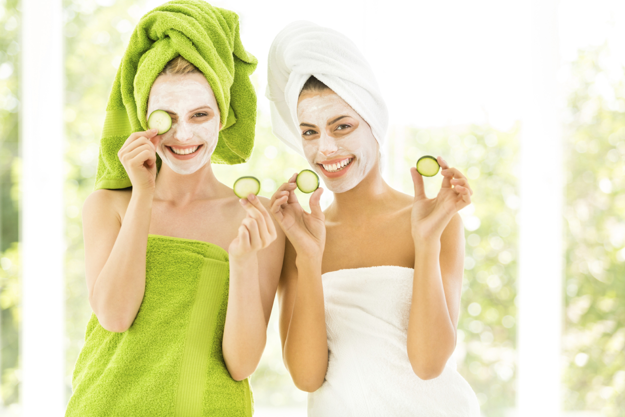 Women holding slices of cucumber