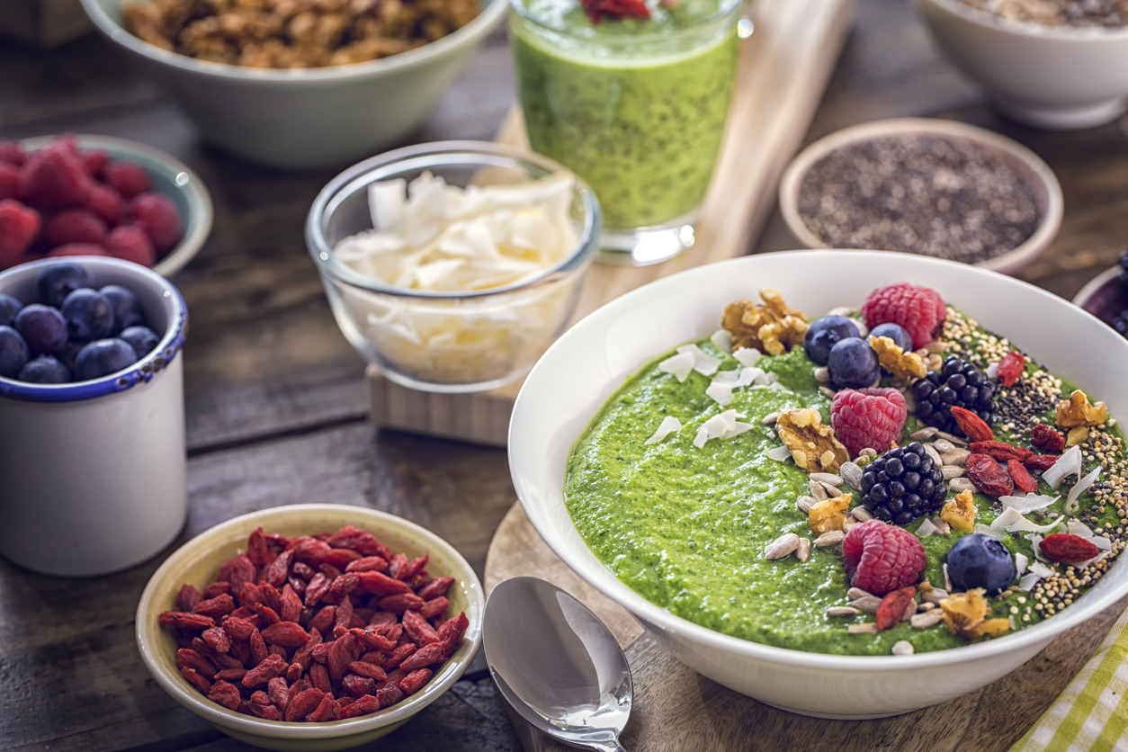 Green Breakfast Smoothie in Bowl with Superfoods on Top