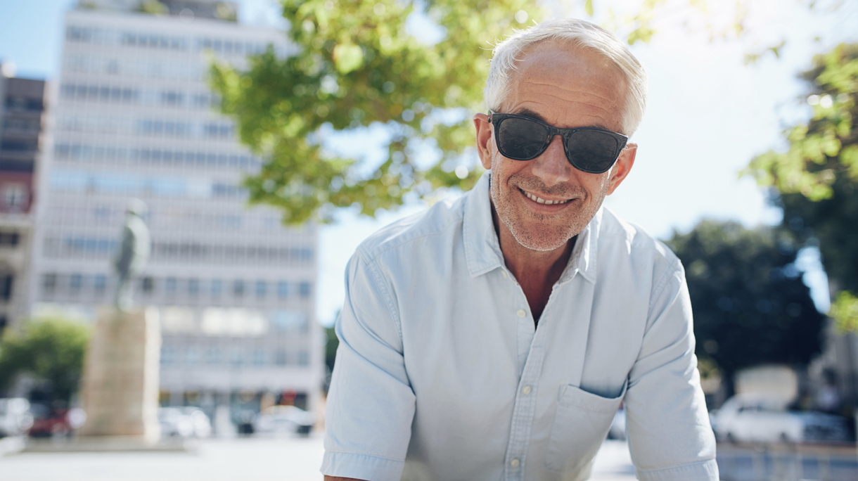 Happy senior man sitting outdoors in the city