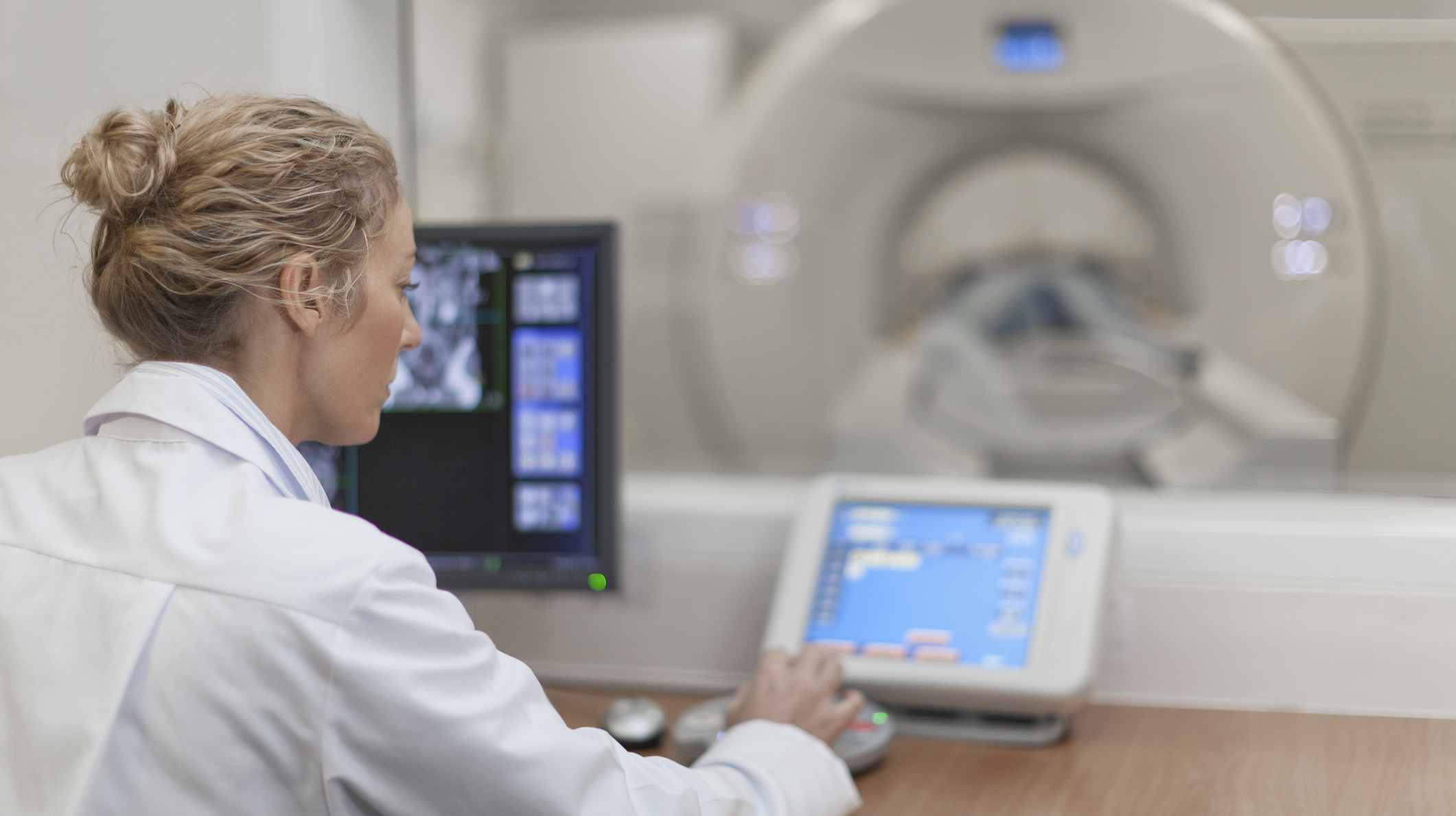 Doctor operating CT scanner in hospital