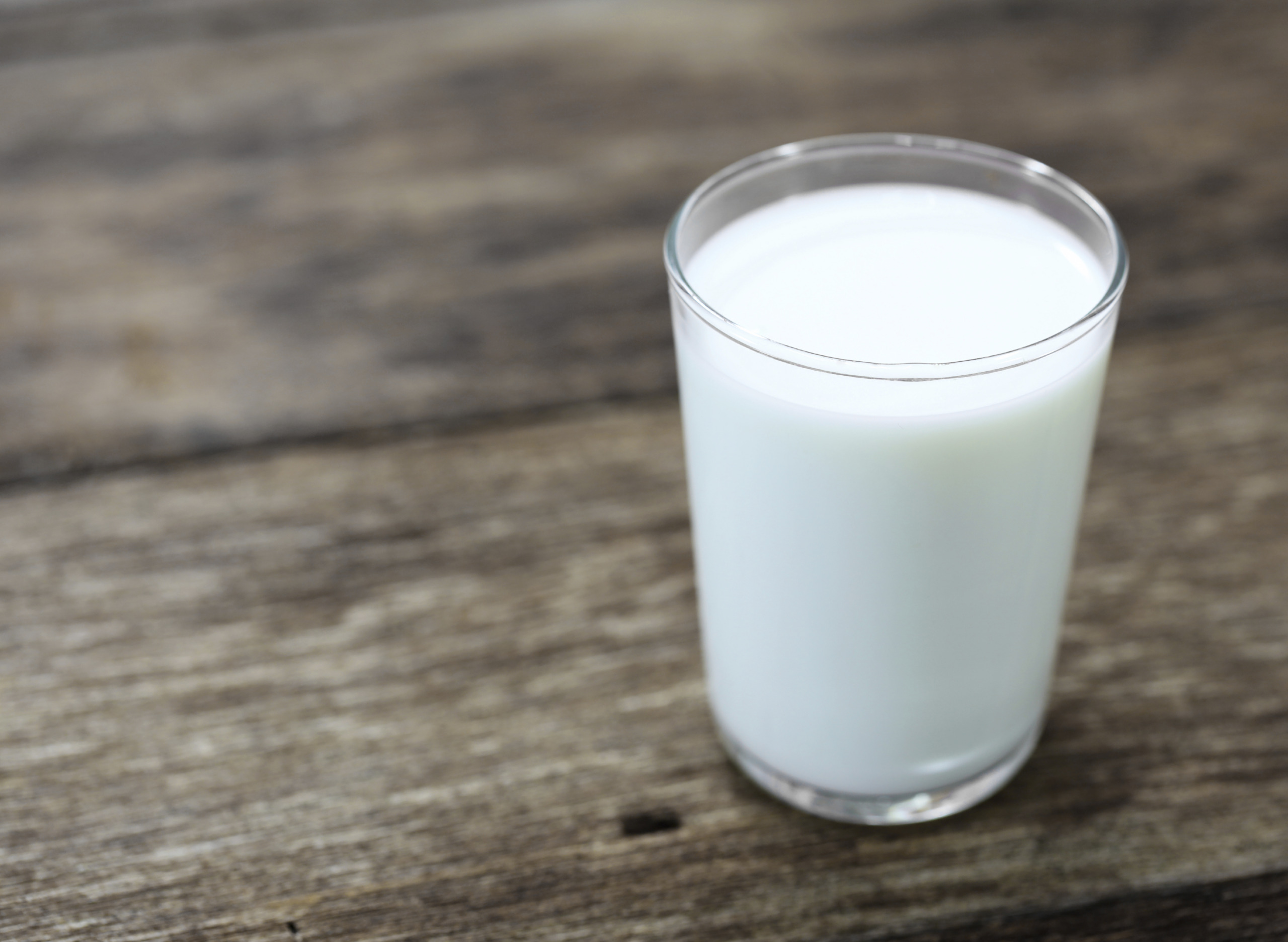 glass of milk on wooden table
