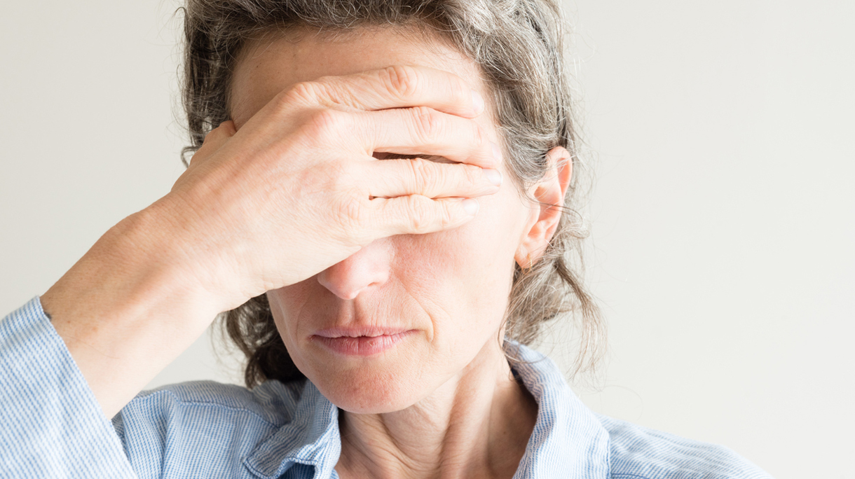 Middle aged woman with hand over eyes