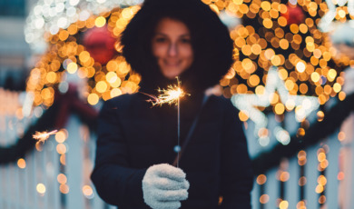 Young woman with burning sparkler for Christmas