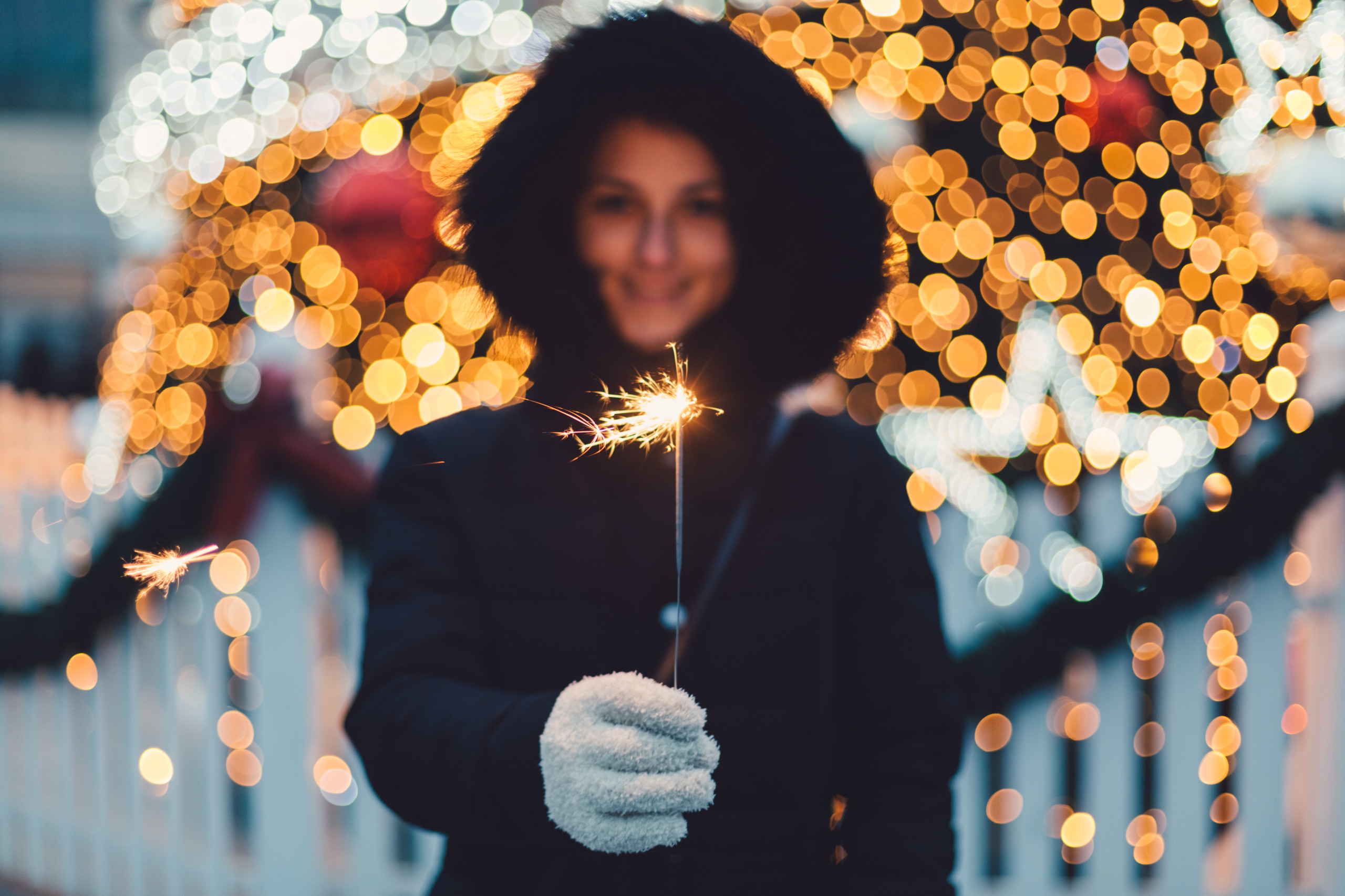 Young woman with burning sparkler for Christmas