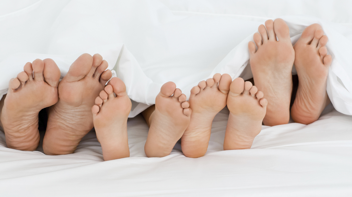 Family on the bed  at home with their feet showing