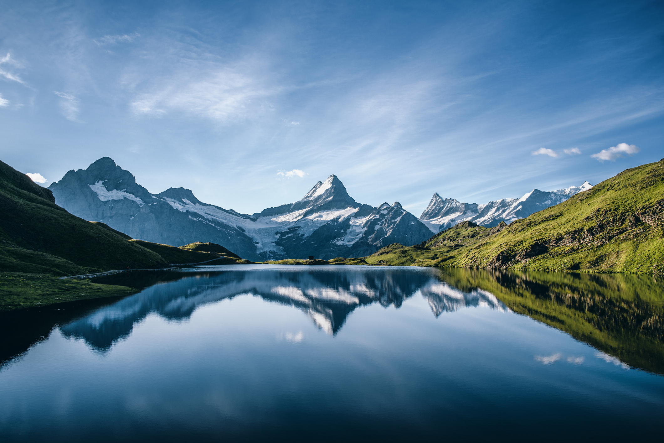 Scenic View Of Lake And Mountains Against Blue Sky