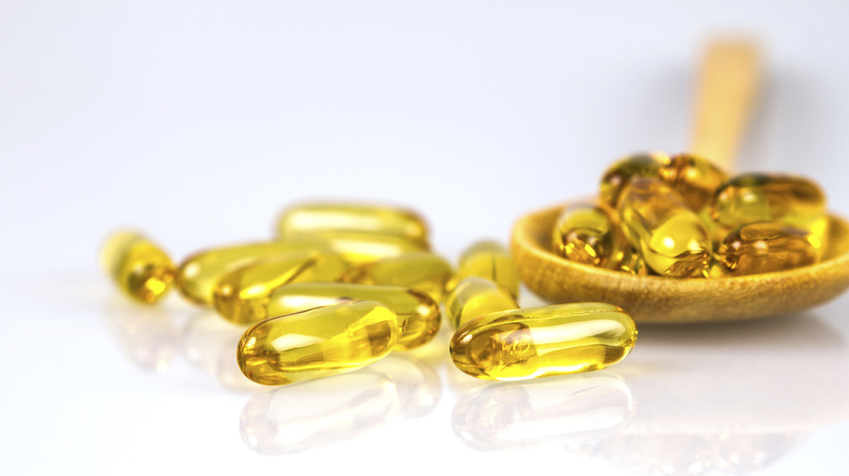 Closeup yellow soft gelatin supplement fish oil capsule