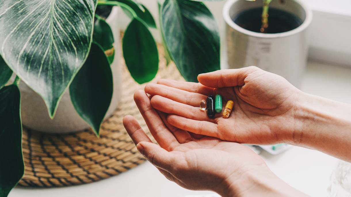 Vrouw met vitaminepillen in haar hand