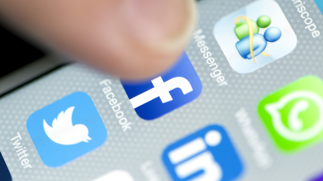 Male Finger is Touching Facebook App on iPhone 6 Screen