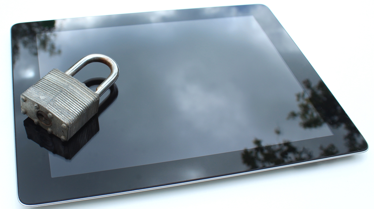 Image of tablet computer with padlock, sky reflections, glass screen