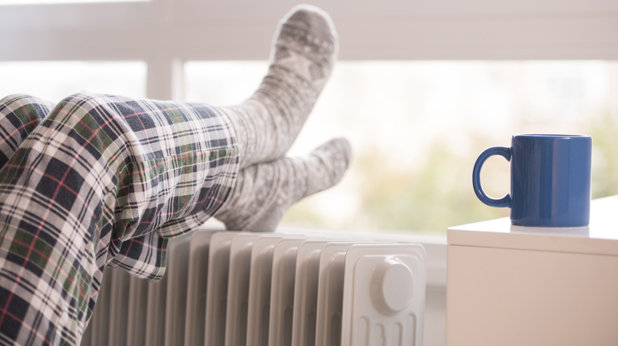 Unrecognized woman warming up her feet in winter.