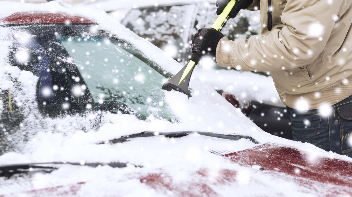 closeup of man cleaning snow from car
