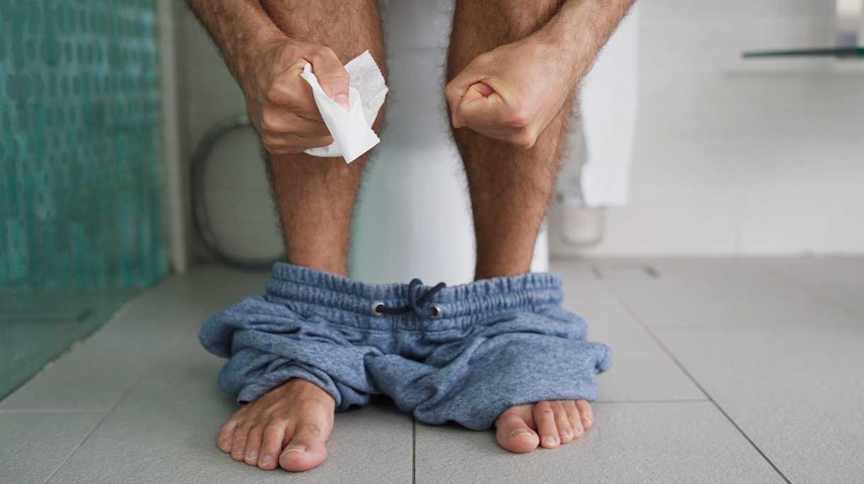 Man zit op het toilet met obstipatie