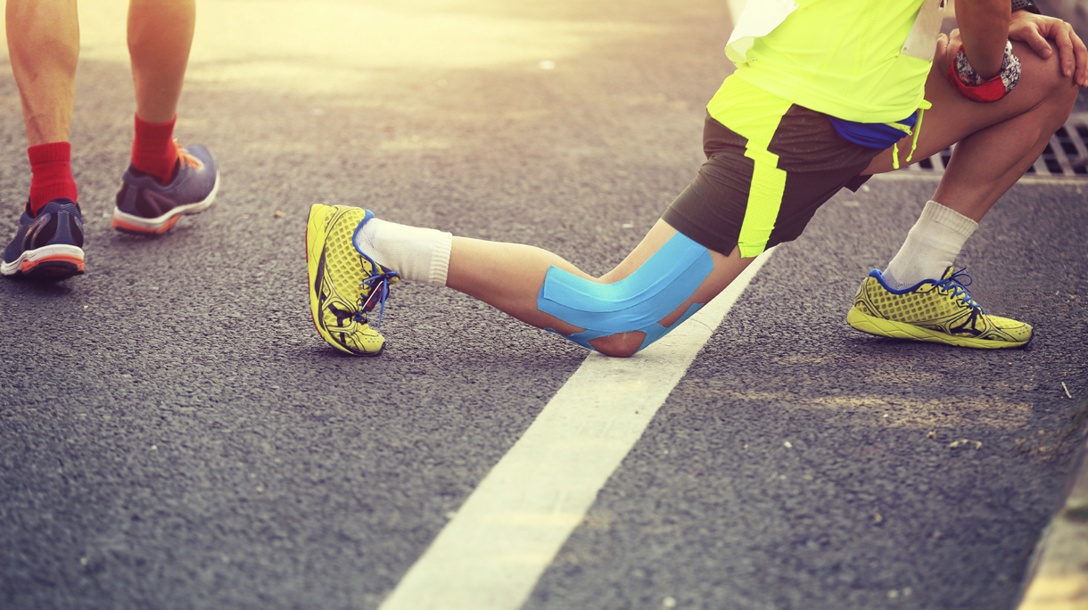marathon runner stretching legs on road