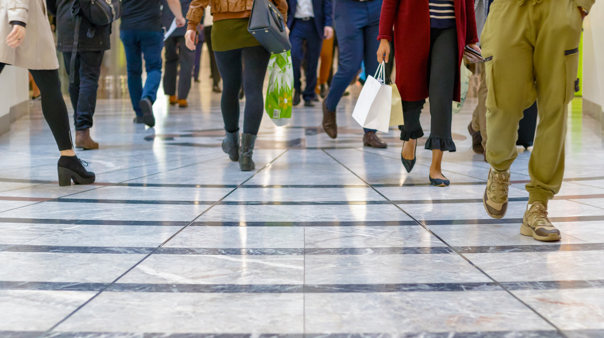A modern floor with legs of a crowd walking in the background