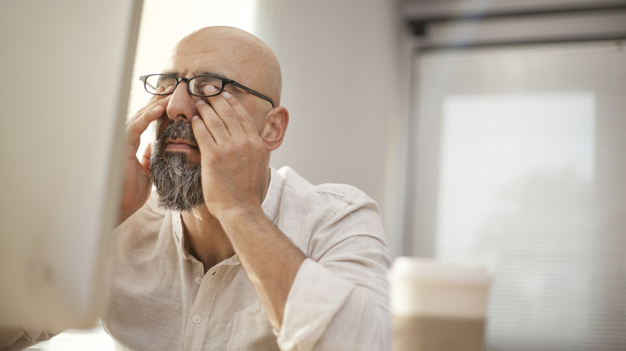 Senior businessman rubbing his tired eyes