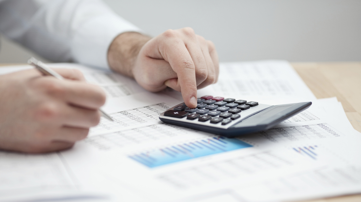 Financial data analyzing. Counting on calculator.