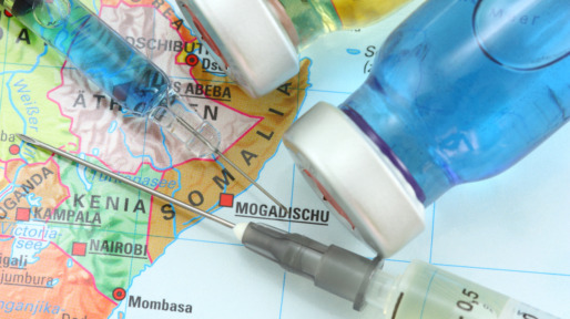 Two hypodermic needles and vaccines on a Somalia map