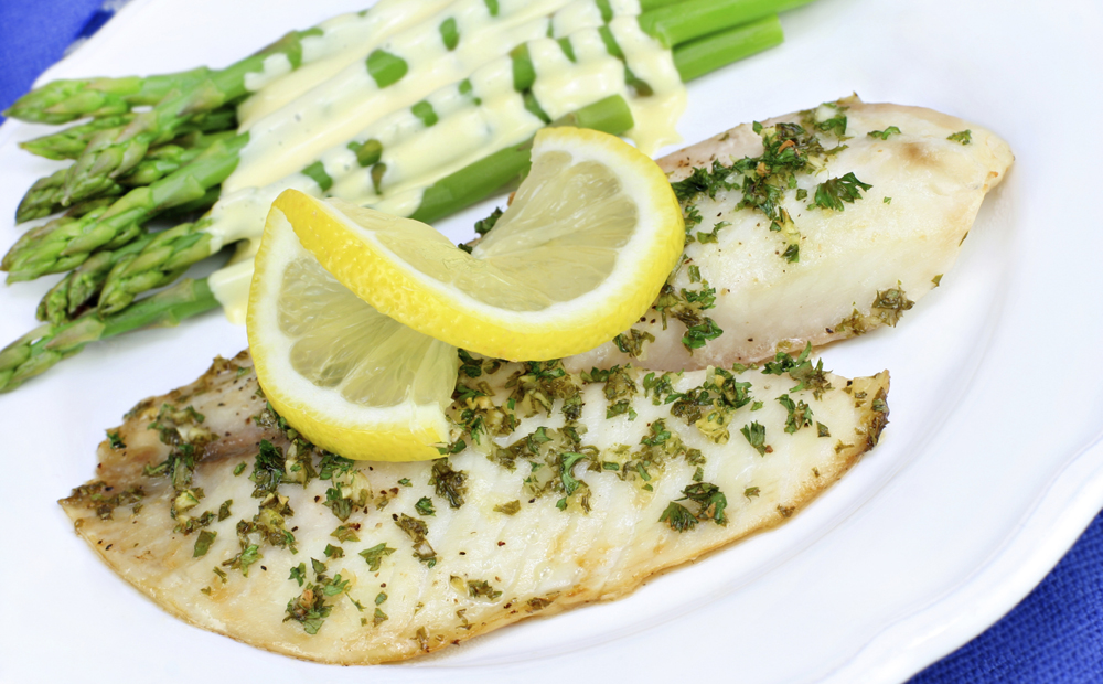 Fresh baked Tilapia fish dinner with asparagus and Hollandaise s