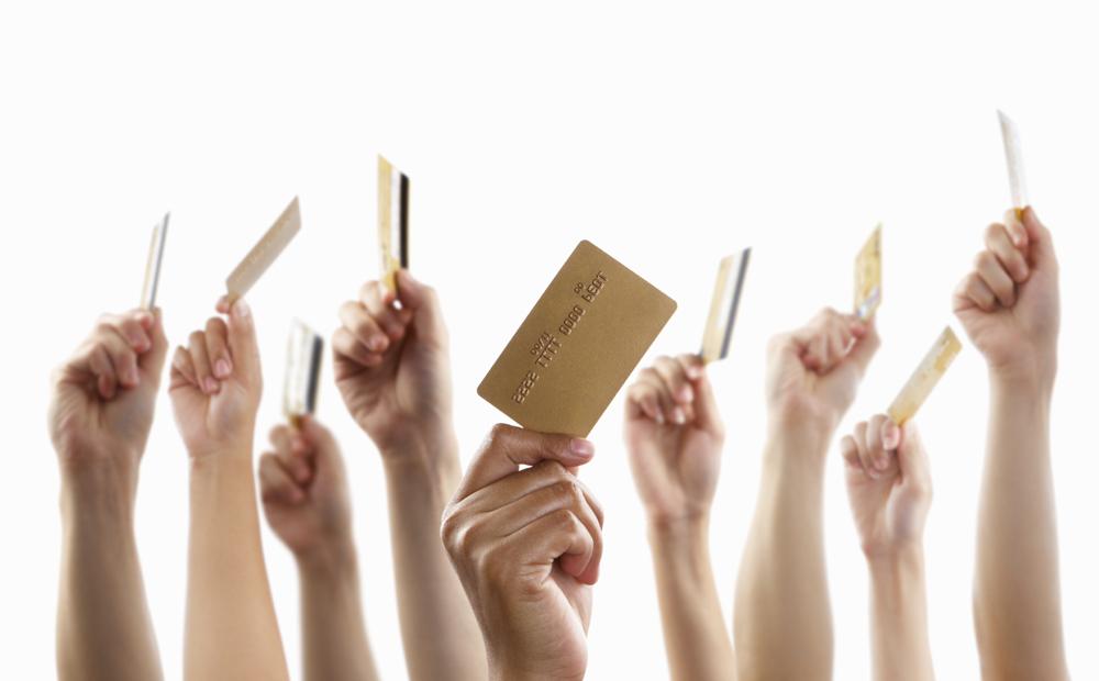 Lot of hands holding gold credit card