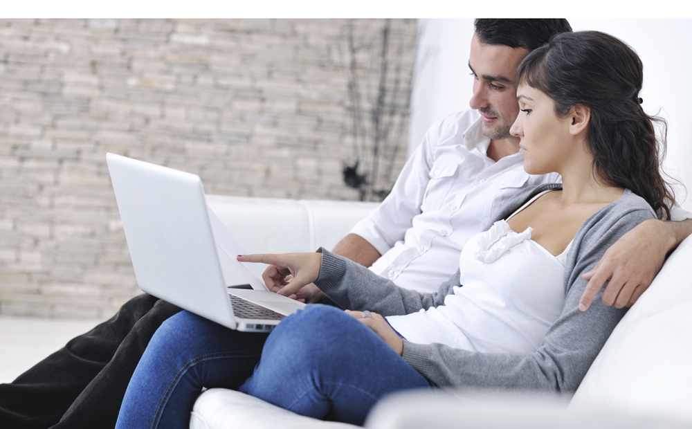 joyful couple relax and work on laptop computer at modern home