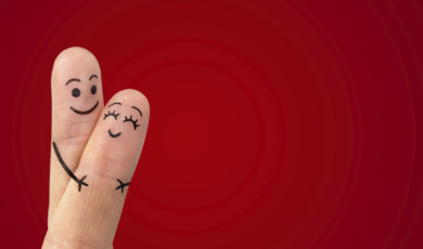 A happy couple in love with painted smiley and hugging