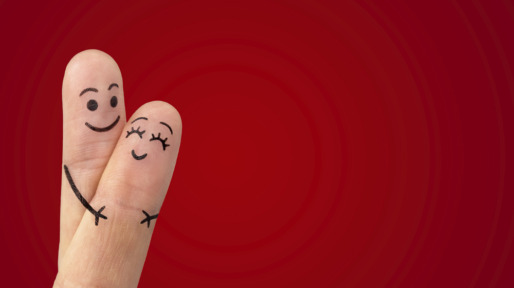 A happy couple in love with painted smiley and hugging
