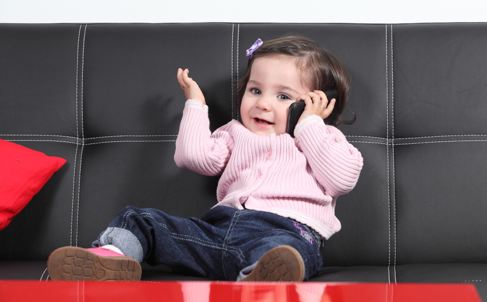 Casual baby playing happy with a mobile phone