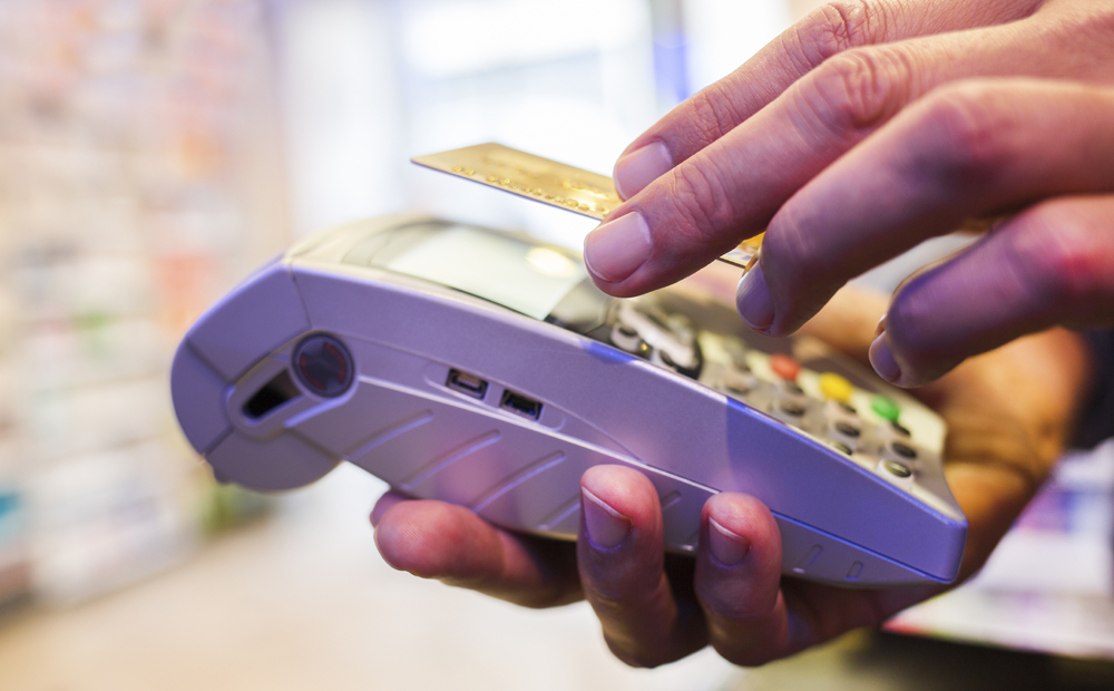 Man paying with NFC technology on credit card, in pharmacy