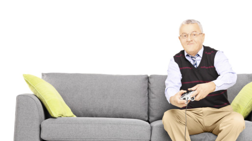 Senior man sitting on a couch and playing video games