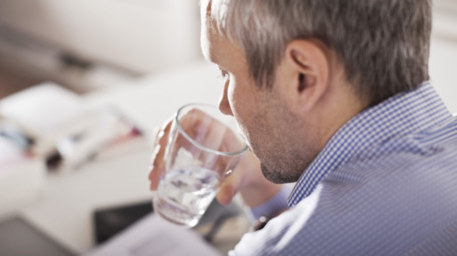 Mature businessman drinking water