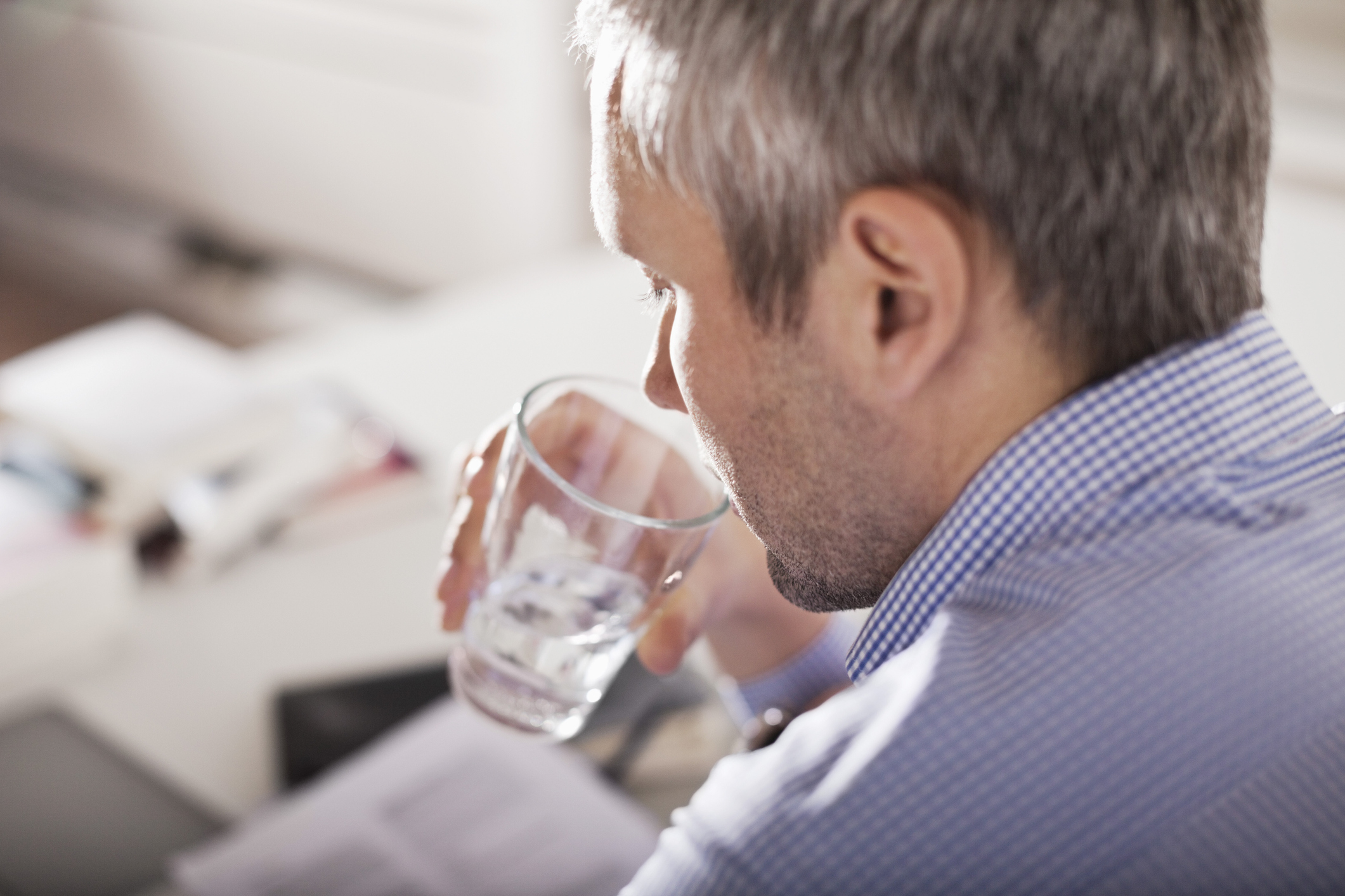 Mature businessman drinking water