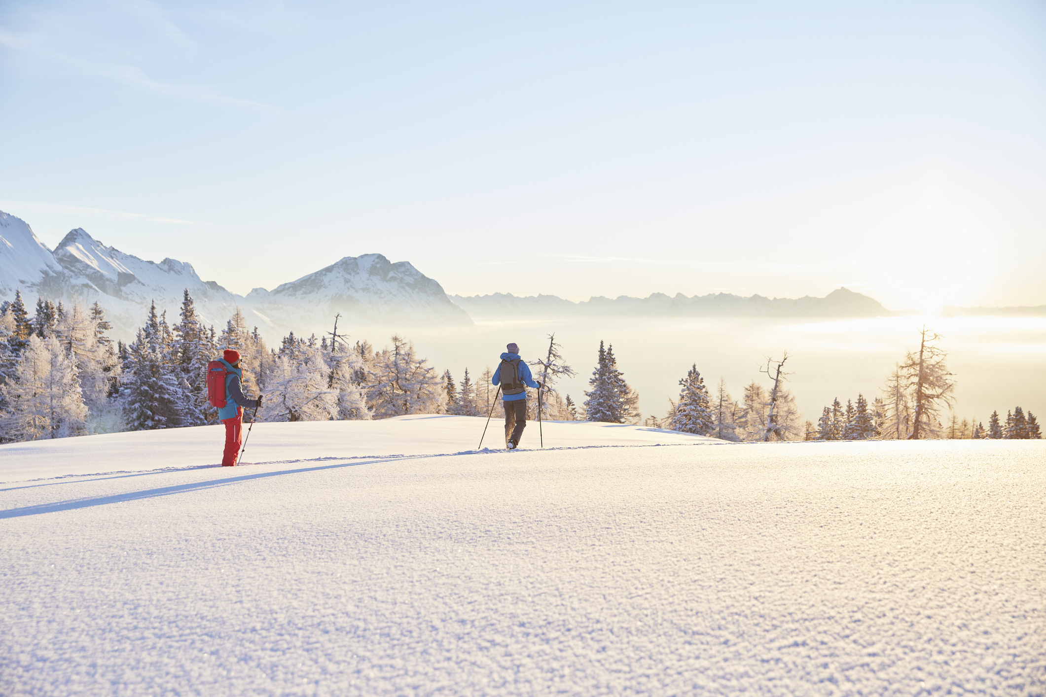 Austria, Tyrol, snowshoe hikers at sunrise