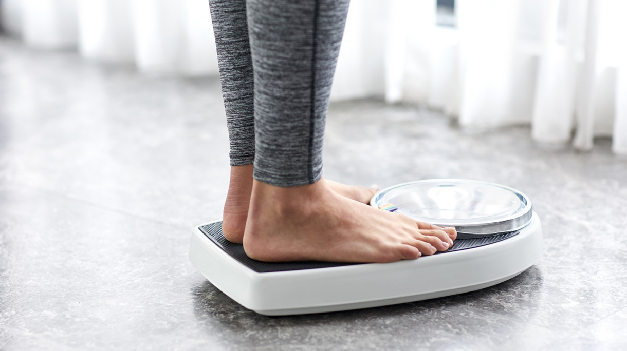 Young healthy girl on home scales