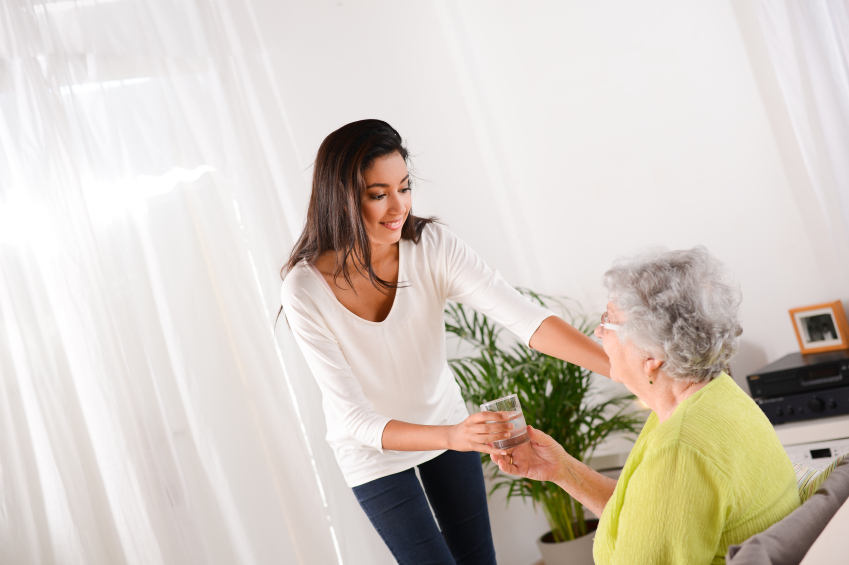 cheerful young girl taking care of elderly woman at home