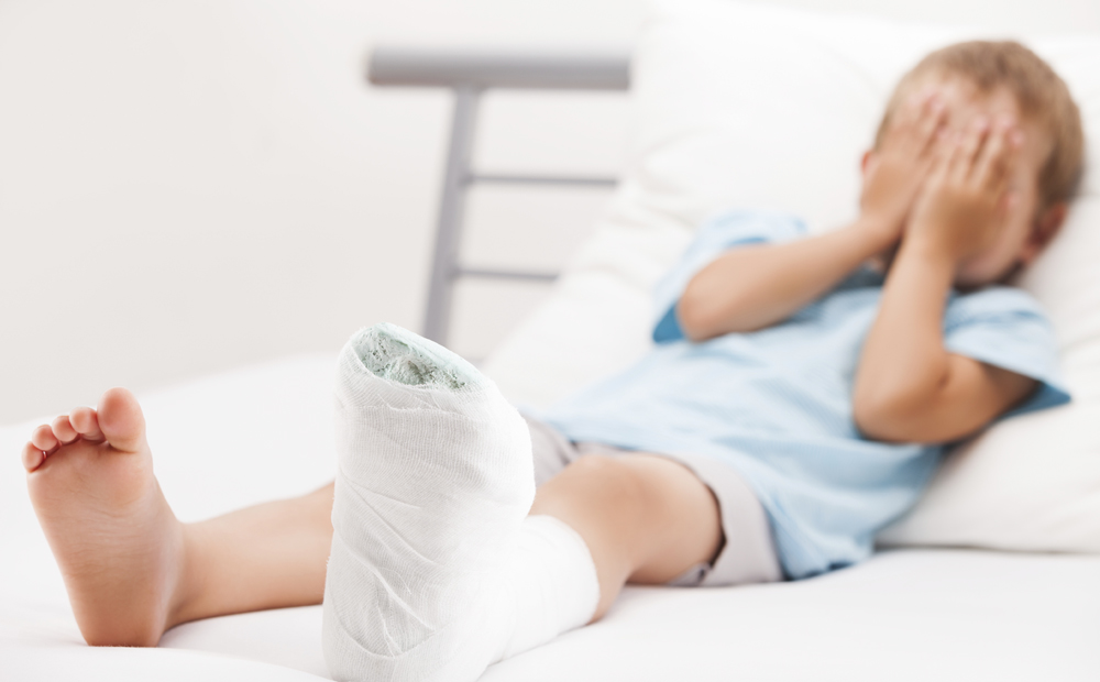 Little child boy with plaster bandage on leg heel fracture or br