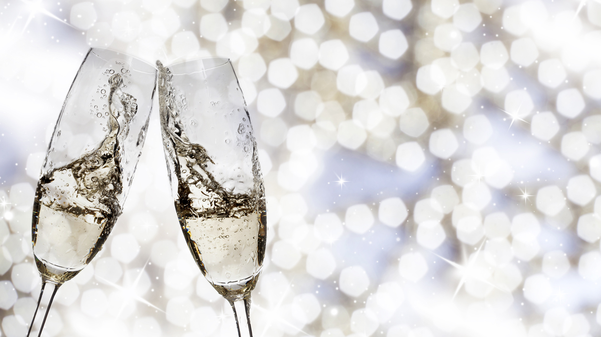 Toasting with champagne glasses on sparkling holiday background