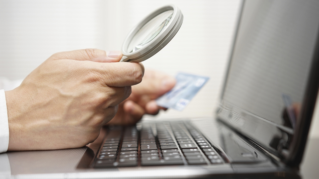 businessman is using magnifying glass  when making online paymen