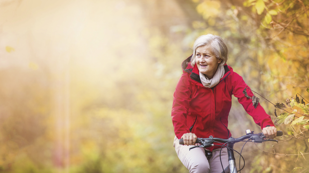 Active senior woman riding bike