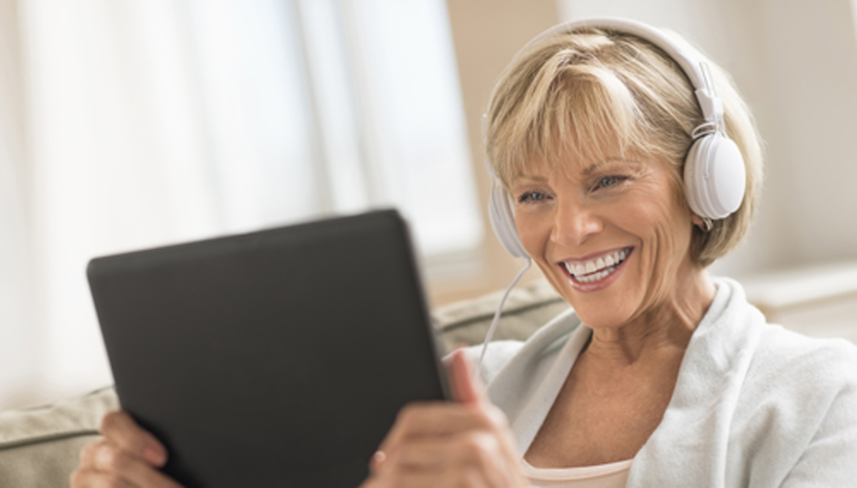 Woman Looking At Digital Tablet While Using Headphones
