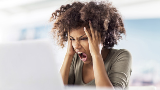 Angry African American woman using computer.