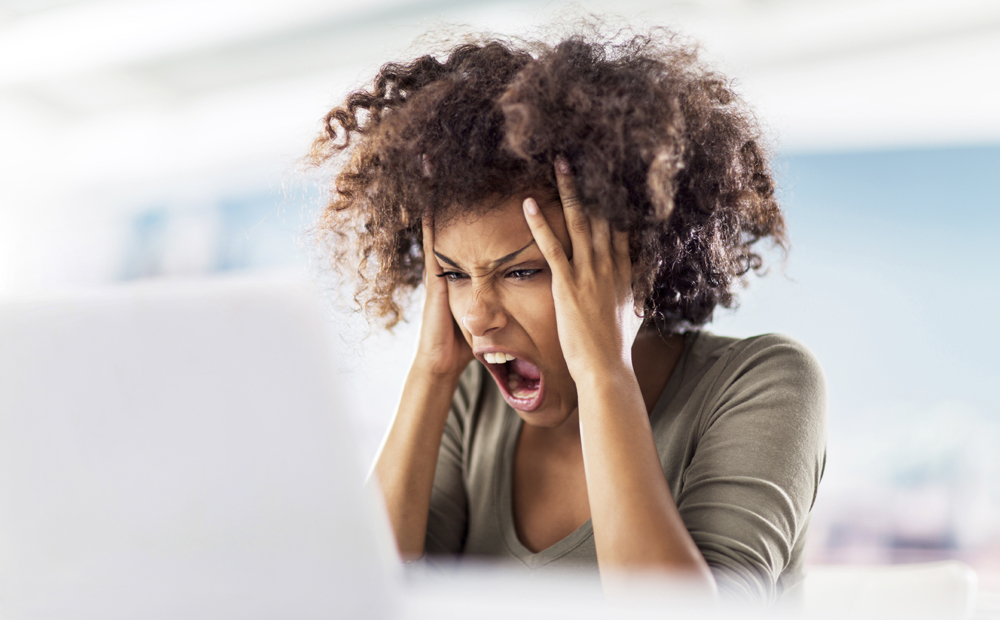 Angry African American woman using computer.