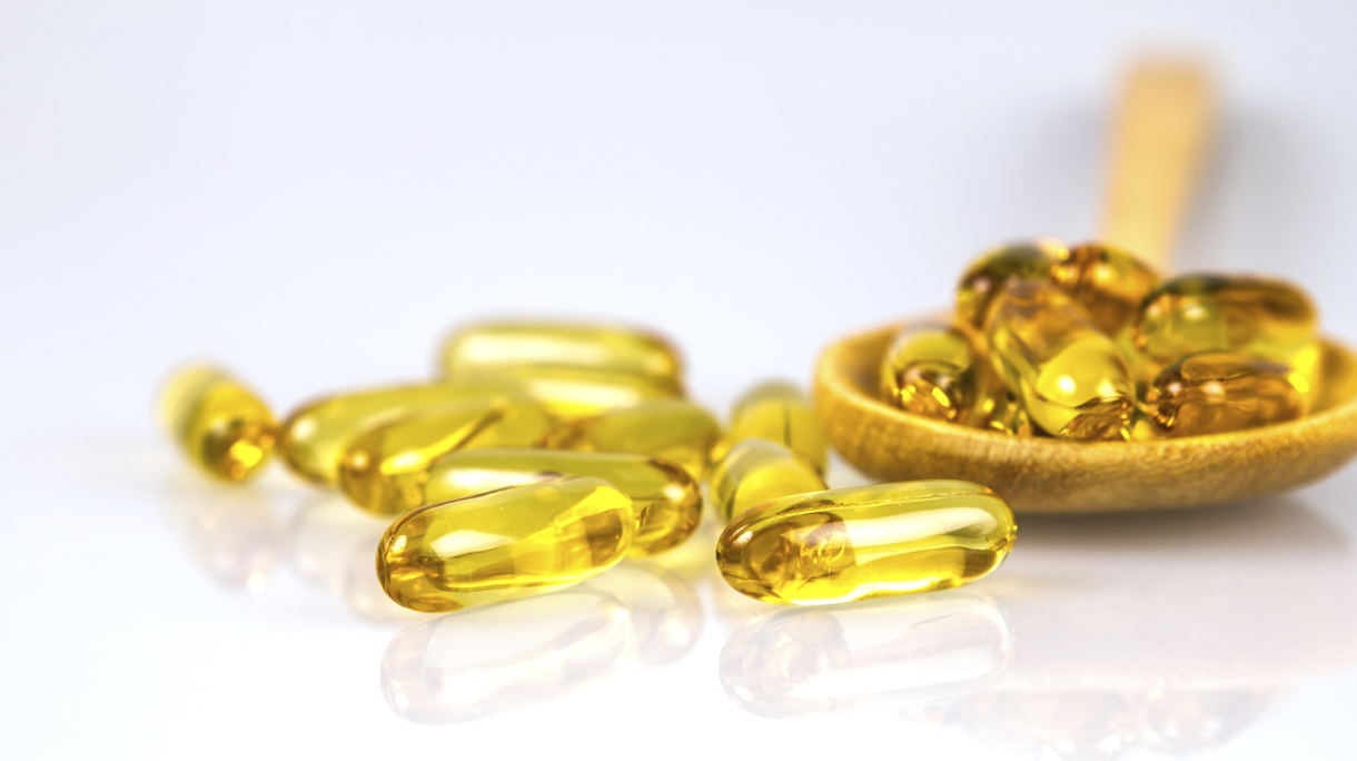Closeup yellow soft gelatin supplement fish oil capsule