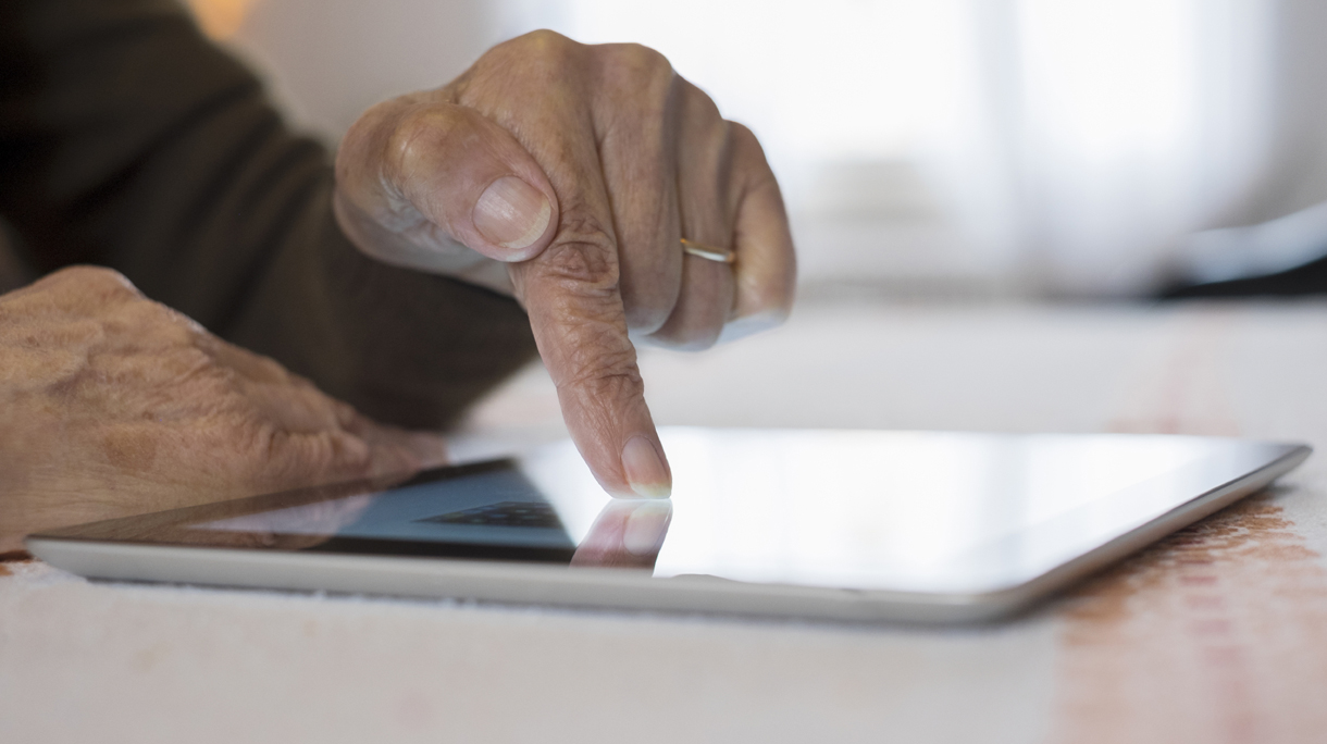 Senior Woman Using Tablet Computer At Home