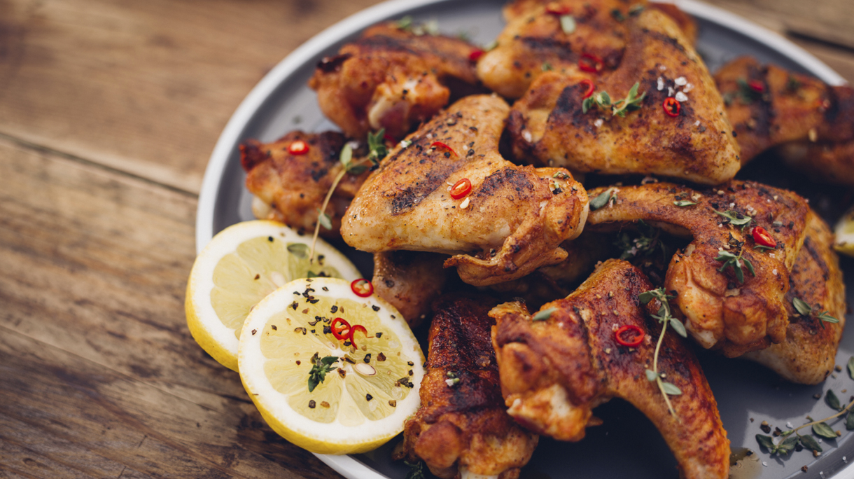 Chillie sprinkled spicy chicken wings on a wooden table