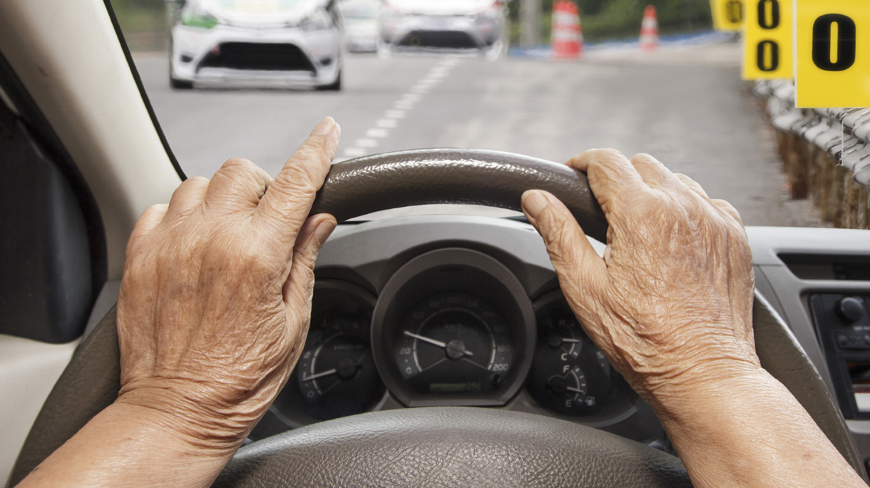 Senior woman driving a car on road.