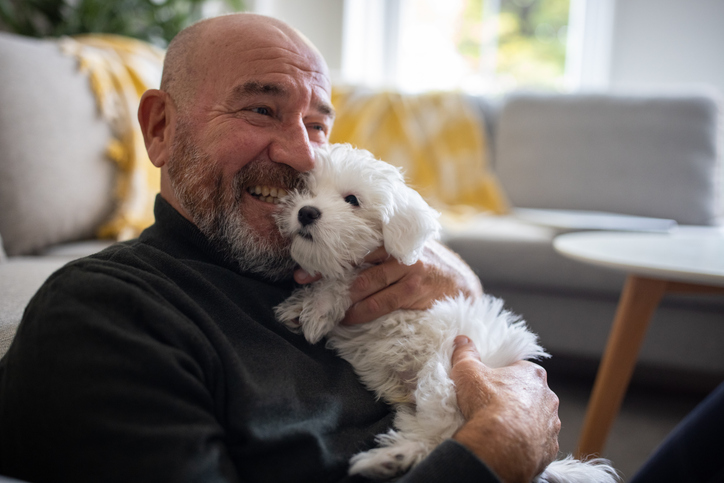 Man op de bank, hond op schoot