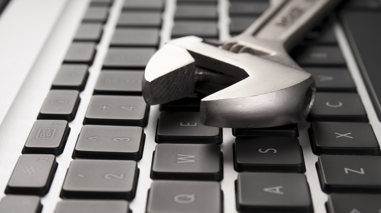 Close up of a keyboard with an adjustable wrench on top